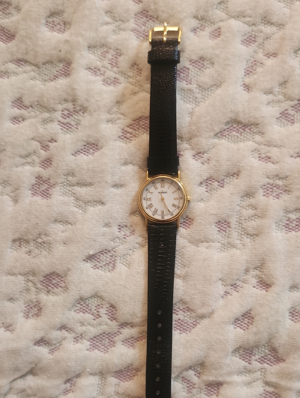 Movado Women's Black Strap Watch with Gold Case and White Dial